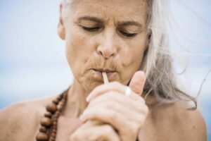 A woman smoking as part of the "California Sober" lifestyle